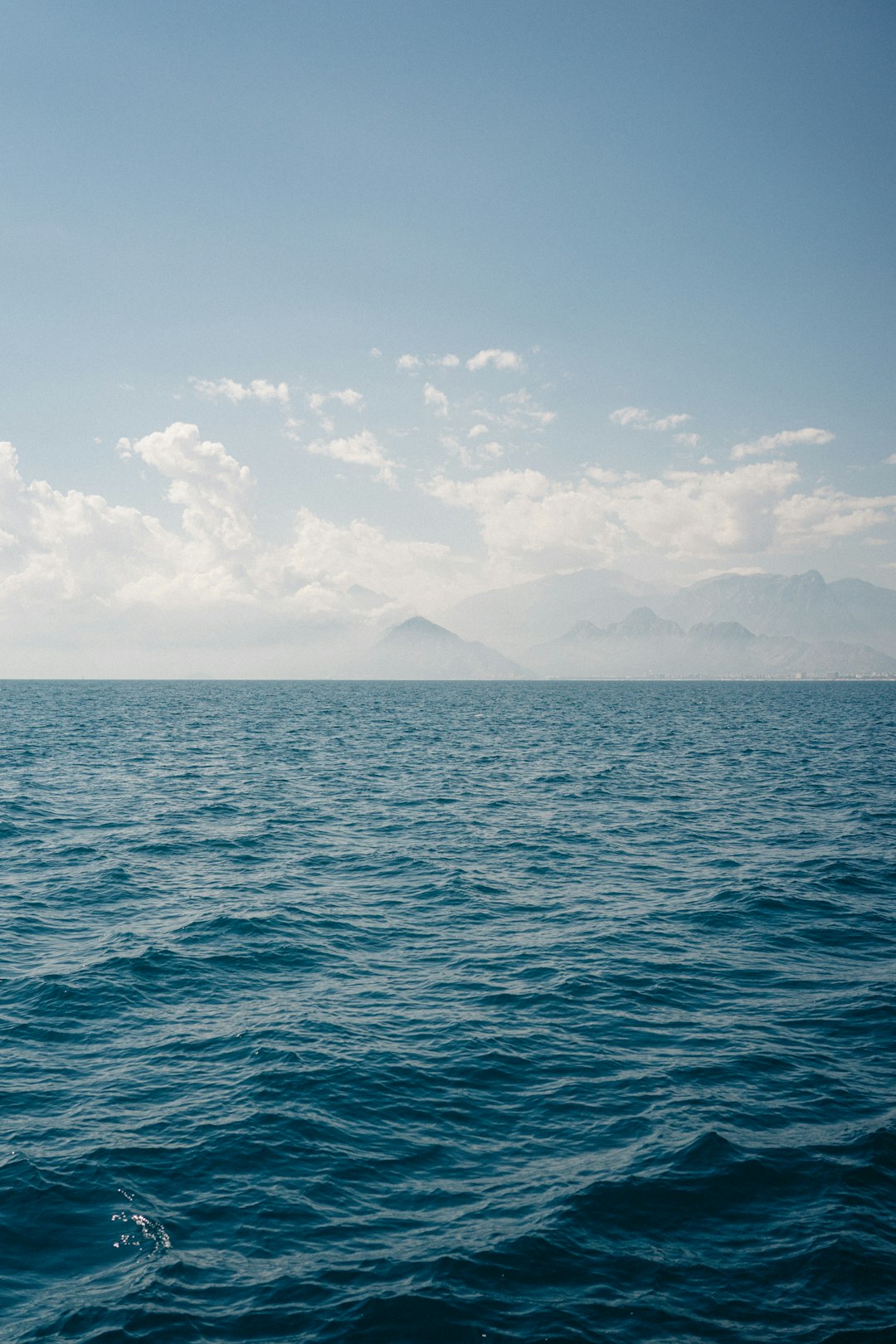 A large body of water sitting under a cloudy blue sky