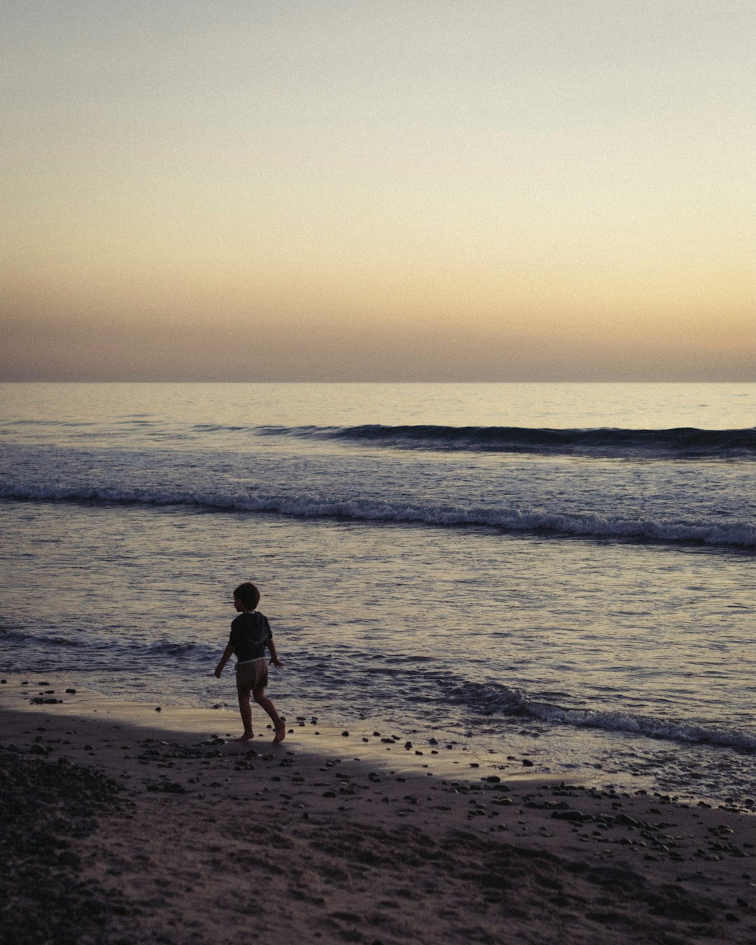 A person walking on a beach near the ocean