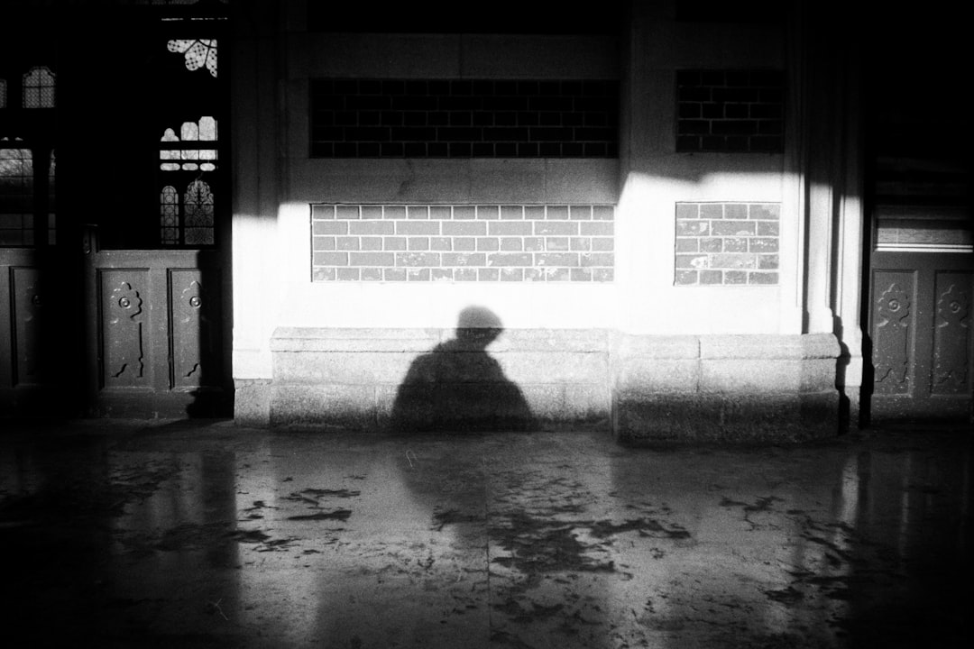 A black and white photo of a person sitting on a bench