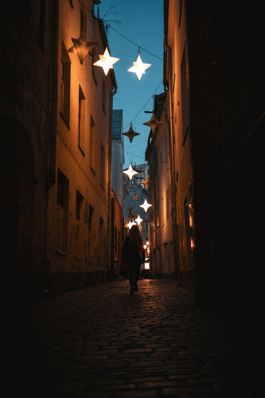 A person walking down an alley way at night