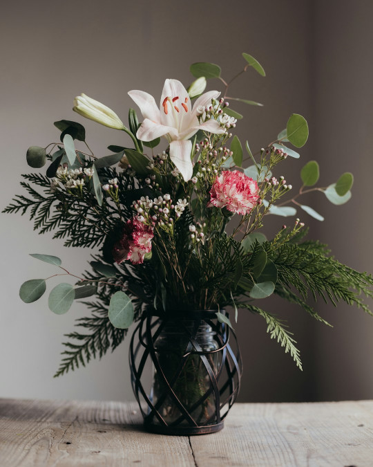 A vase filled with flowers on top of a wooden table