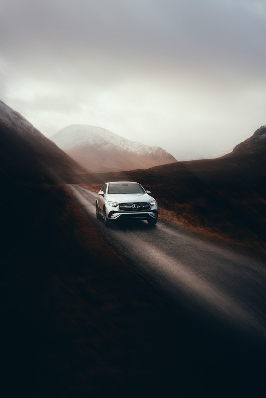 A white car driving down a mountain road