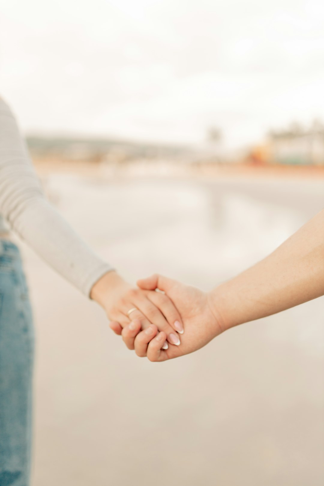 A man and a woman holding hands on a beach